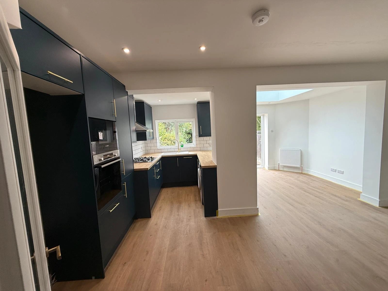 Navy kitchen with oak worktops opening into a rear extension