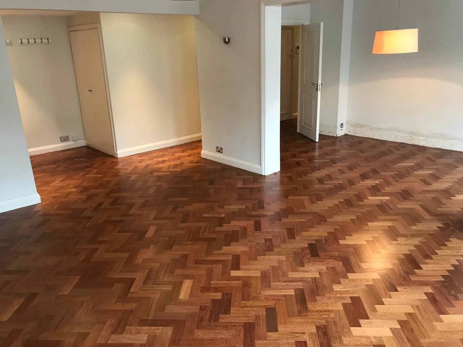 Hardwood herringbone parquet floor finished through an open plan room