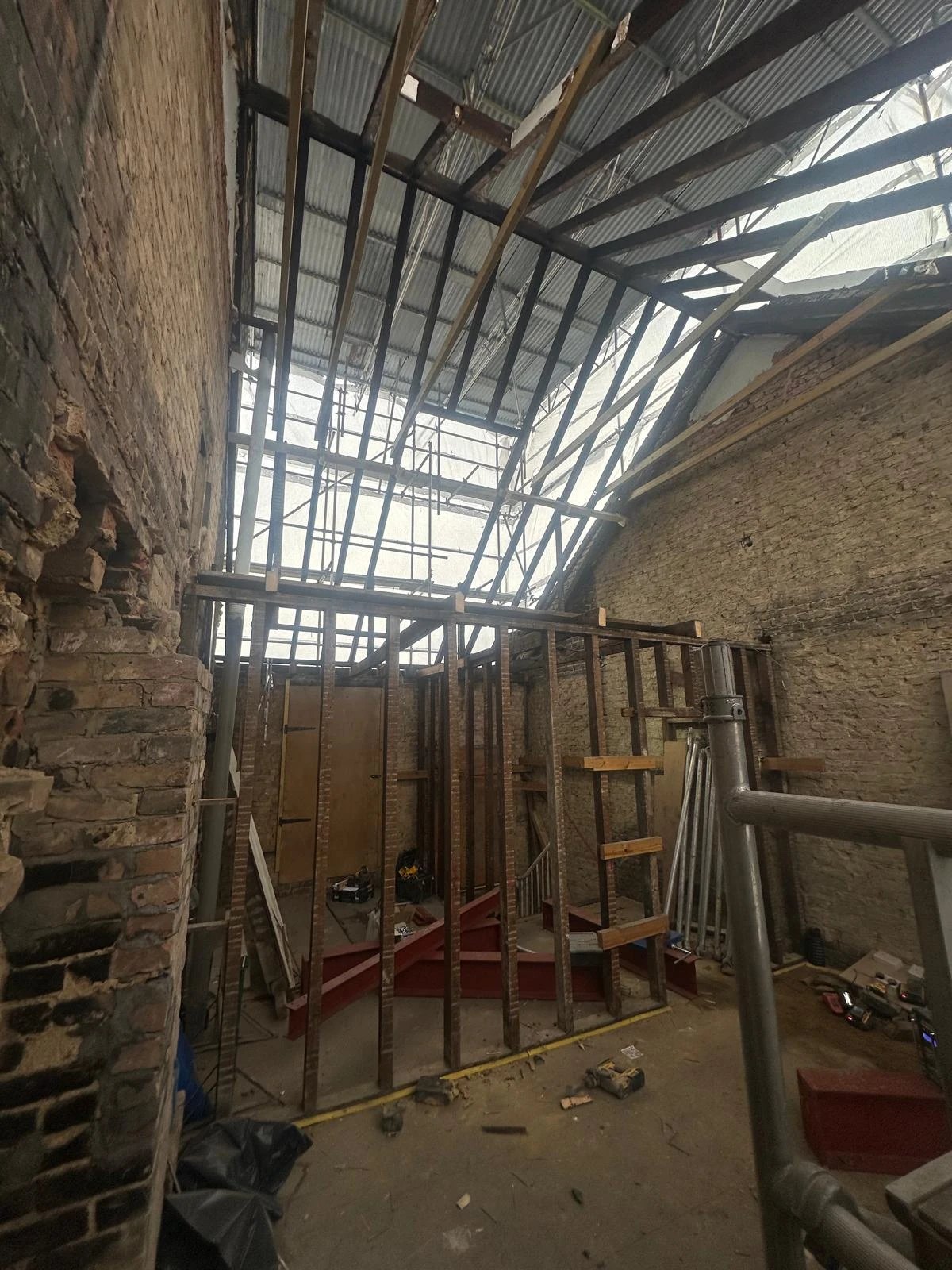 Terraced house with the old roof stripped and new steels in under scaffold